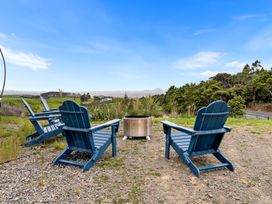 An outdoor seating area with chairs and a fire pit at Waipu Hilltop Escape - Waipu Cove