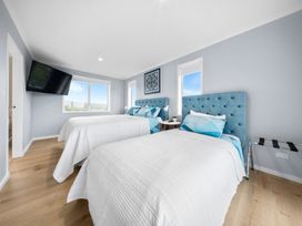 A bedroom with two beds and a television at Waipu Hilltop Escape - Waipu Cove
