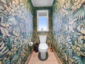 A bathroom with a toilet and a window at Waipu Hilltop Escape - Waipu Cove
