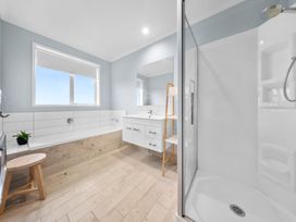 A bathroom with a bathtub, shower, and sink at Waipu Hilltop Escape - Waipu Cove