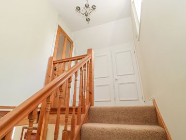 A staircase with wooden railing leading to a landing with white paneled doors at Fenwick Retreat at Fenwick near Ponteland