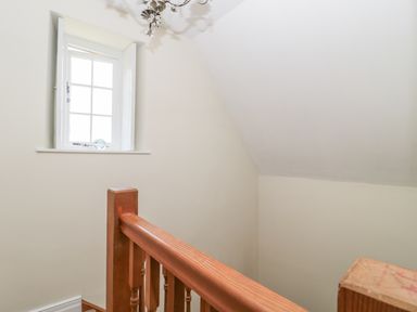 A staircase with wooden railing and a window on a wall at Fenwick Retreat at Fenwick Lodge in Fenwick near Ponteland