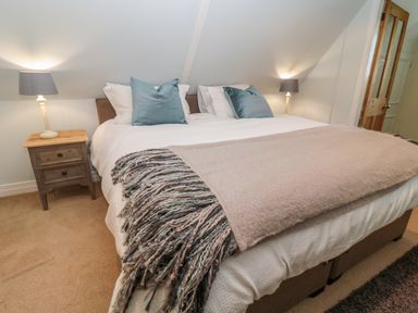 A bedroom with a bed with pillows and a blanket and nightstands with lamps on each side at Fenwick Retreat at Fenwick Lodge Fenwick near Ponteland