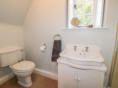 A bathroom with a toilet and a sink under a window at Fenwick Retreat at Fenwick Lodge Fenwick near Ponteland