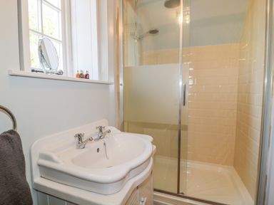 A bathroom with a white sink a glass shower enclosure and a window at Fenwick Retreat at Fenwick Lodge in Fenwick near Ponteland