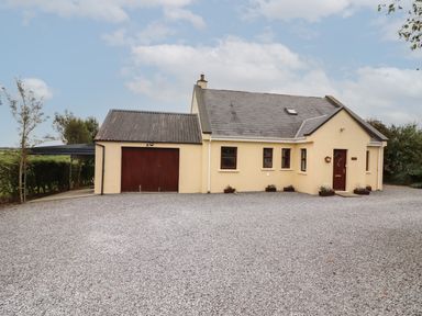 A house with a gravel driveway and attached garage at Silver Birch in Dromelihy Cooraclare County Clare