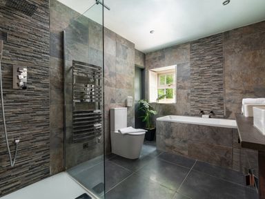 A bathroom with a bathtub toilet sink and glass-enclosed shower at Sykes Lodge in Malton