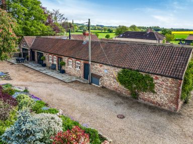 An outdoor view of a building with garden and seating area at Sykes Lodge in Malton