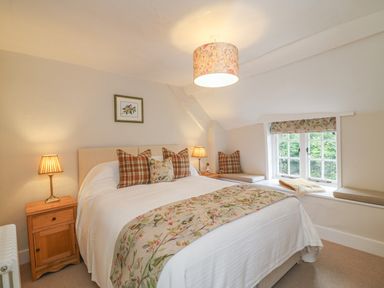 A bedroom with a double bed and floral decorations at Rookwood in Drewsteignton