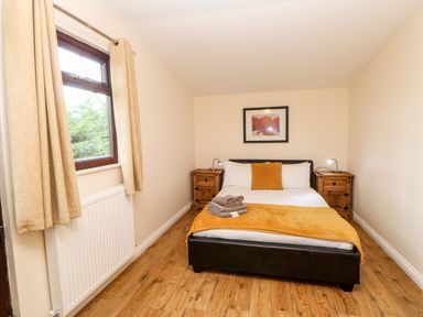 A bedroom with a double bed bedside tables and a window at Daffodil Lodge in Saltburn-by-the-Sea