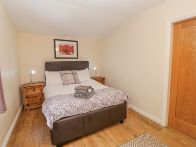 A bedroom with a double bed bedside tables and a framed flower picture on the wall at Orchid Lodge in Saltburn-by-the-Sea