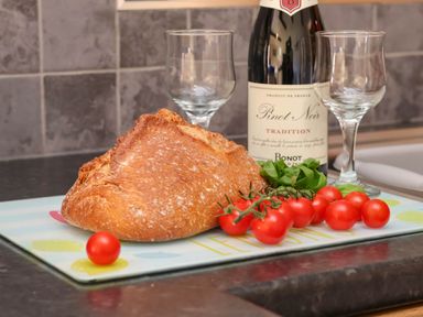 A kitchen counter with bread, wine, and tomatoes at Orchid Lodge Saltburn-by-the-Sea