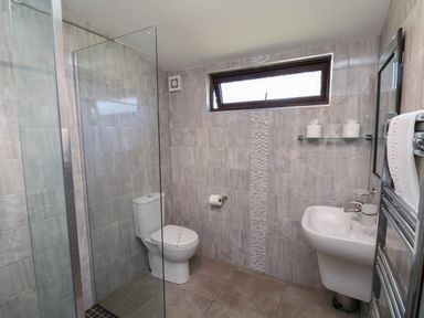 A bathroom with a shower, toilet, and sink at Orchid Lodge in Saltburn-by-the-Sea