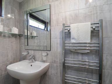 A bathroom with a sink, mirror, and towel rail at Orchid Lodge in Saltburn-by-the-Sea