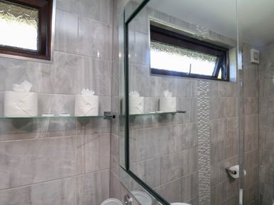 A bathroom with a mirror and toilet paper on a shelf at Orchid Lodge in Saltburn-by-the-Sea