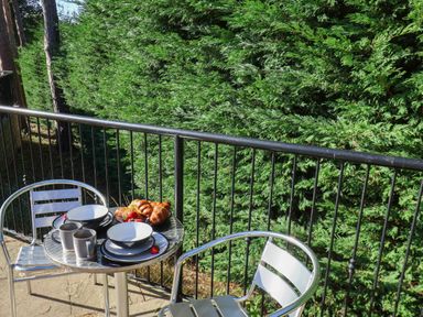A balcony with a table set for breakfast at Orchid Lodge in Saltburn-by-the-Sea