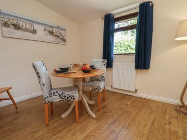 A dining room with a round table and chairs at Foxglove Lodge in Saltburn-By-The-Sea