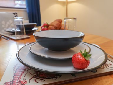 A table setting with bowls plates and strawberry at Foxglove Lodge Saltburn-By-The-Sea