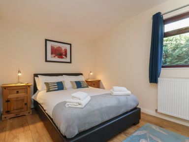A bedroom with a bed and nightstands at Foxglove Lodge in Saltburn-By-The-Sea