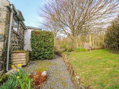 A garden with gravel path lawn hedge flowering plants and a fence at Higher Lampra Mullion