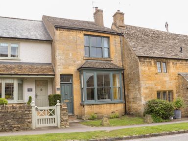 Stone cottages with green doors and windows with a small front garden at The Cottage at Broadway in Broadway