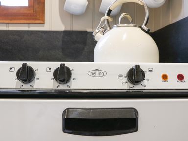Close up of oven dials and a white kettle on a stove at Little Silver Leaf in High Bickington