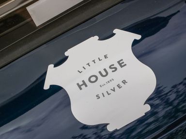 A close up of a window decal showing Little House Silver logo on a dark surface at Little Silver Leaf in High Bickington