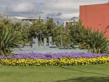 A garden with yellow and purple flowers and a model ship among bushes at The Manor House in Scarborough