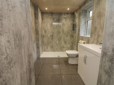 A bathroom with a shower enclosure a toilet and a sink cabinet at The Manor House in Scarborough