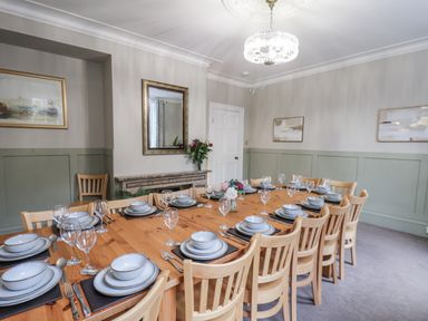 A dining room with a large table set for a meal at The Manor House in Scarborough