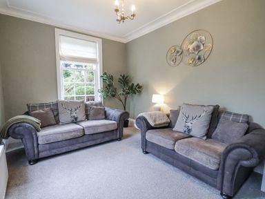A living room with two sofas and a lamp at The Manor House in Scarborough