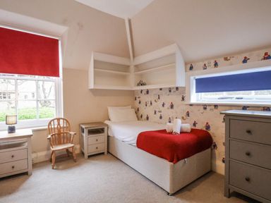 A bedroom with a bed and shelves at The Manor House in Scarborough