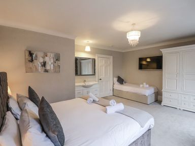 A bedroom with beds and a wardrobe at The Manor House in Scarborough