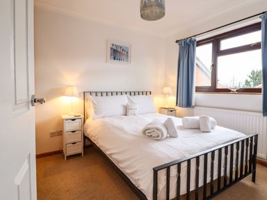A bedroom with a bed and bedside tables with lamps at Sea-Prize View in Old Colwyn