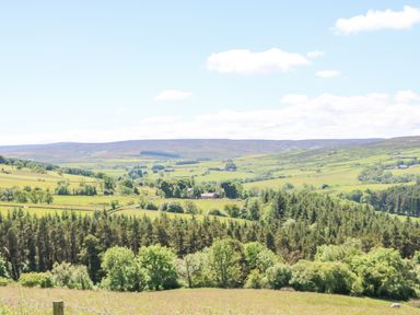 A rural landscape with fields trees and hills at Dale View Cottage in Allendale near Hexham