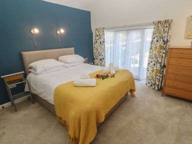A bedroom with a bed and curtains at Meadowside Mousehole