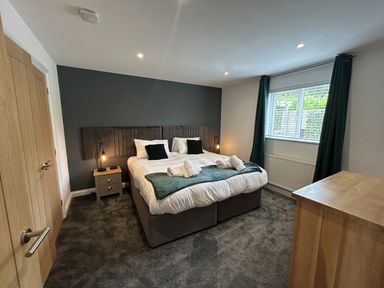 A bedroom with a bed and two nightstands at Willow, Retallack near St Columb Major