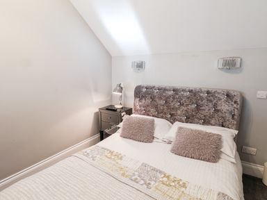 A bedroom with a bed a bedside table and a lamp at Tawny Cottage in Irton Moor near Scarborough