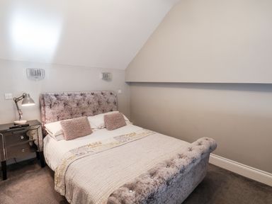 A bedroom with a bed a side table and a lamp at Tawny Cottage in Irton Moor near Scarborough