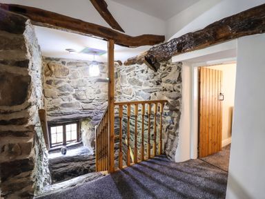 A stone wall staircase with wooden railing and a wooden door at Cwm Yr Afon Mawr in Llanbedr near Harlech
