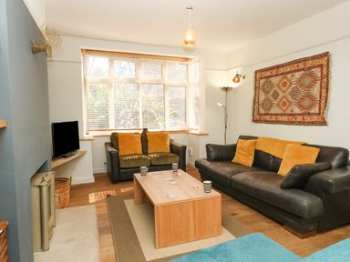 A living room with two leather sofas and a wooden coffee table at Sandsfoot Rest in Weymouth