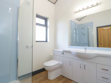A bathroom with a shower enclosure toilet vanity with sink and mirror at Foxglove in Sticklinch West Pennard Glastonbury