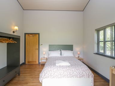 A bedroom with a bed with floral bedding and two bedside tables with lamps at Foxglove in Sticklinch West Pennard Glastonbury