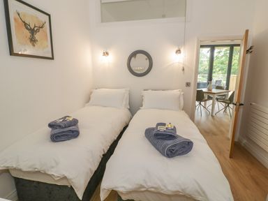 A bedroom with two single beds each with folded towels and toiletries on top at The Barn in Droitwich Spa