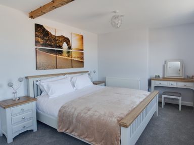 A bedroom with a bed nightstands and a dressing table with a mirror at Low Tide Weymouth