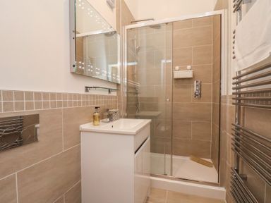 A bathroom with a shower and sink at Evening Star @ Engine Shed in Whitby