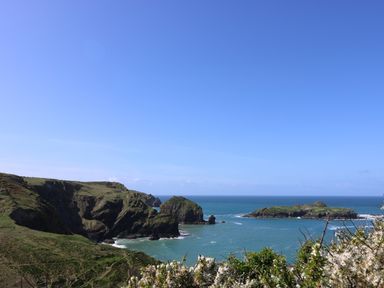A coastal landscape with cliffs and an island in the sea at Kober House in Mullion