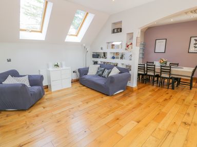 A living room with two sofas and a dining area with a table and chairs at Horeb Chapel House in Tanygrisiau