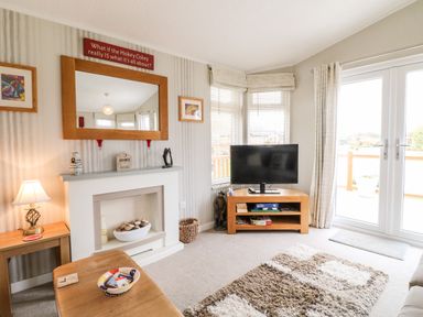 A living room with a fireplace television and wooden furniture at Lake View Lodge in Marston near Barkston