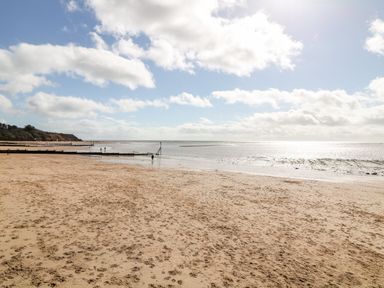 A beach with sand and ocean at Meadow View Cottage in Lympstone